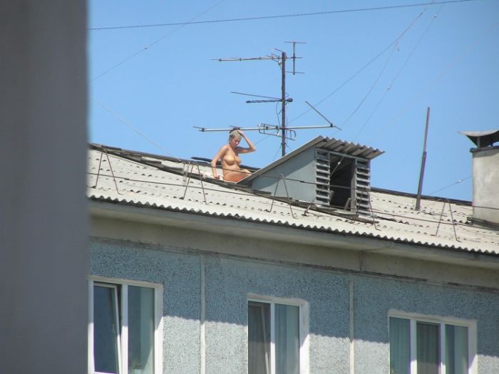 Голые девчата выделываются на крыше дома