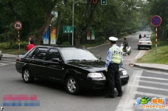 Китайский полицейский сдерживает толпу машин (12 фото)