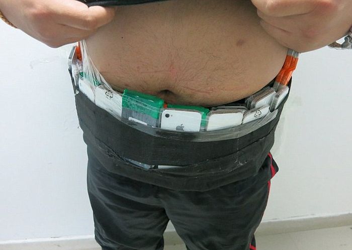 В Китае задержан контрабандист, пытавшийся провезти 146 смартфонов, примотанных к своему телу (3 фото)