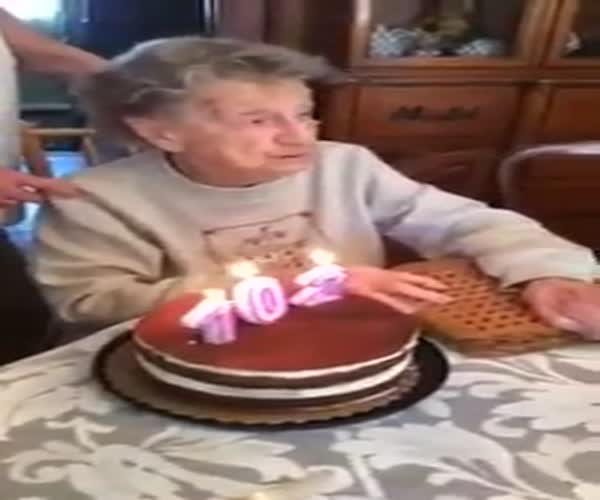 Бабушка задувает праздничный торт