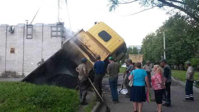 В Санкт-Петербурге грузовик с асфальтом провалился в огромную яму на дороге (3 фото)