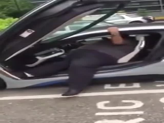 Тучный мужчина с трудом выбирается из машины