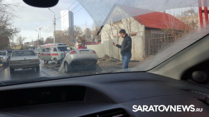 В Саратове автомобиль провалился в огромную яму на дороге (6 фото)