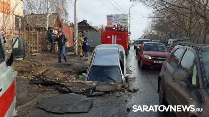 В Саратове автомобиль провалился в огромную яму на дороге (6 фото)