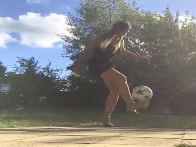 Девушка в платье и на каблуках набивает мяч