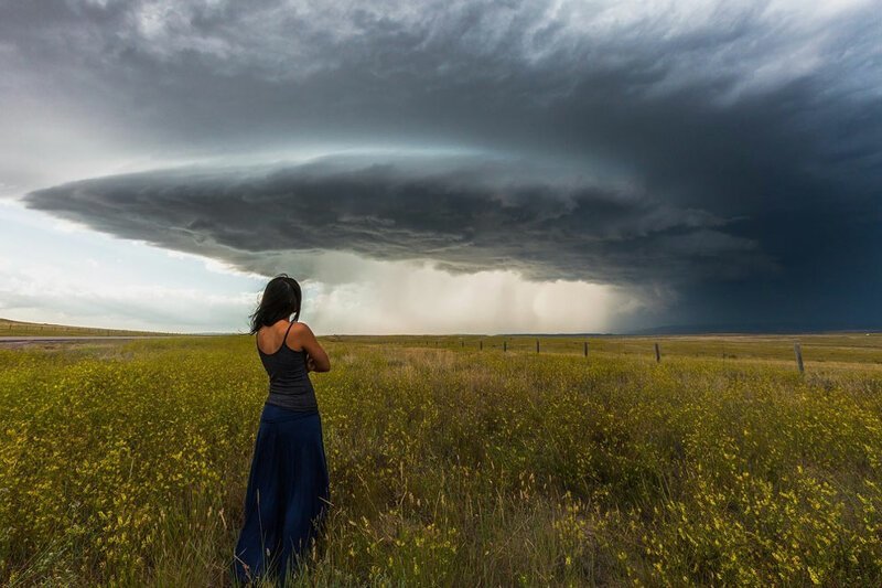 Женщину фотографируют на фоне торнадо