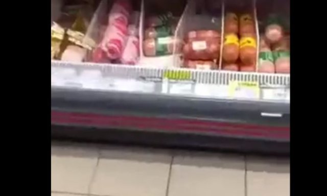 кот есть колбасу в магазине