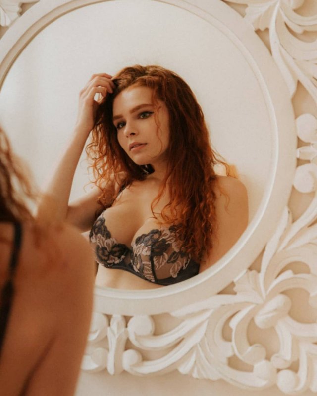 Карина Силантьева в нижнем белье смотрит на себя в зеркало