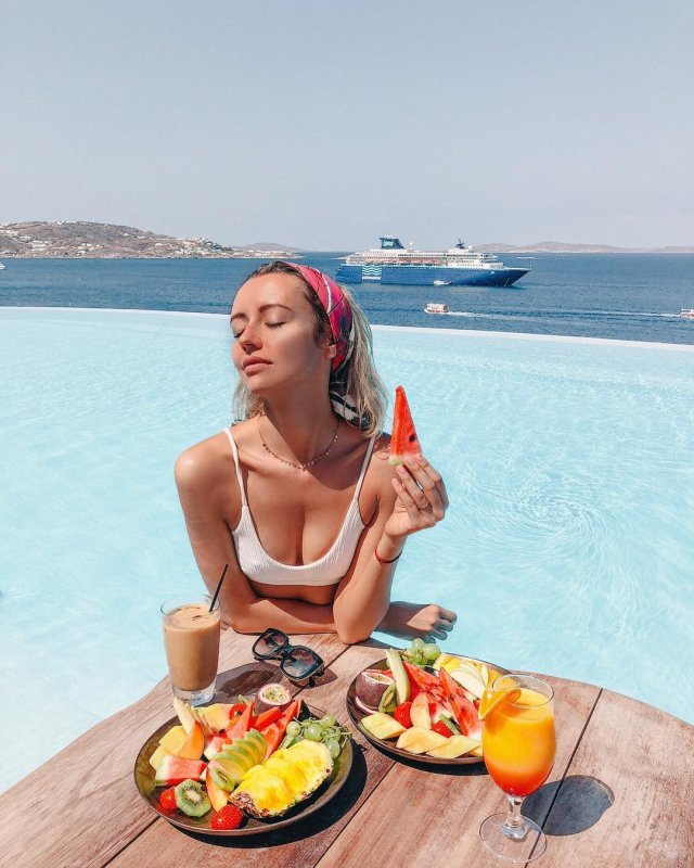 Наталья Османн завтракает фруктами в бассейне на море