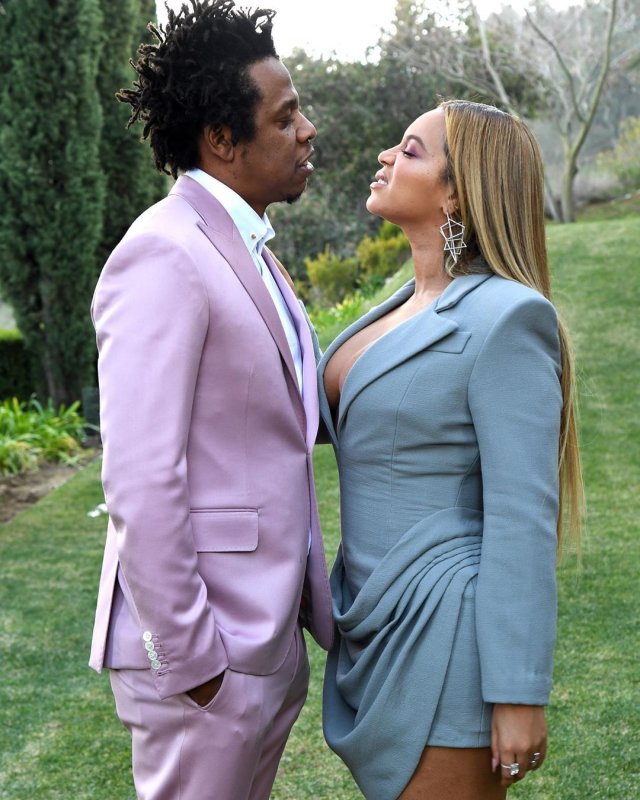 Бейонсе в голубом костюме и Jay-Z в розовом