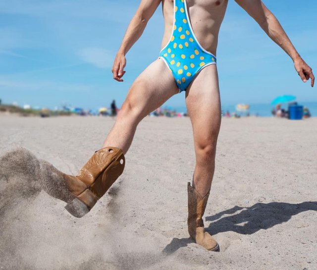 Мужчина в сапогах на пляже в &quot;бикини для мужчин&quot;