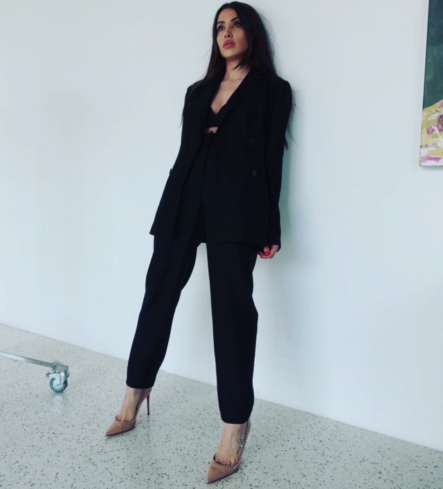 Новая девушка Ильи Прусикина из Little Big - Ксения Красовская в черном пиджаке и брюках у стены