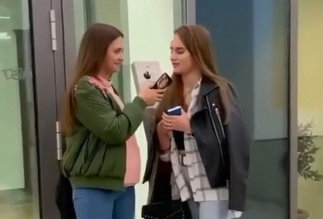 Две девушки в одежде casual разговаривают между собой