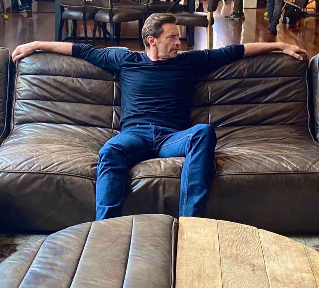 Хью Джекман в синей кофте на диване