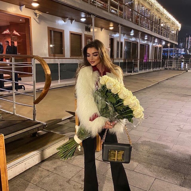 Модель Дарья Иванова в белой шубе с цветами на причале Модель Дарья Иванова в белой шубе с цветами на причале