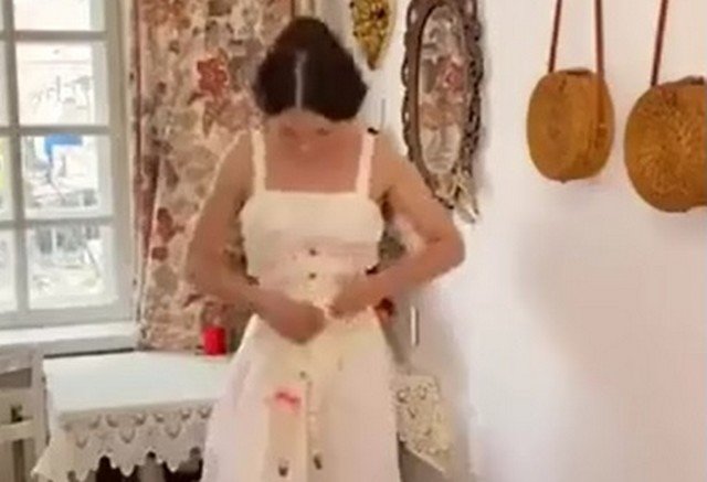 Девушка надевает платье