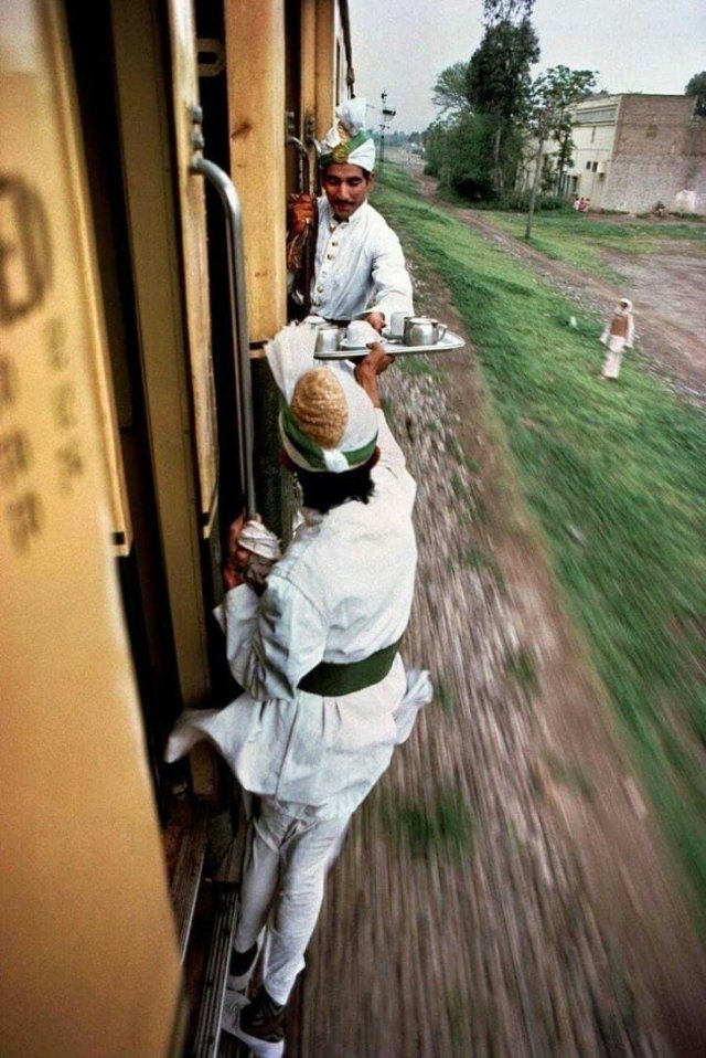 Проводники передают чай для завтрака из одного вагона в другой, Пакистан, 1983 год.