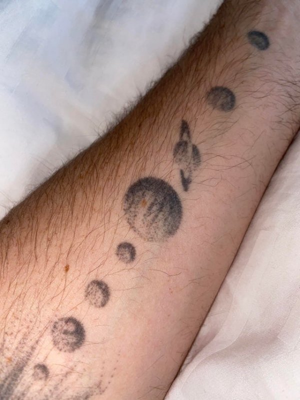Парень сделал татуировку Солнечной системы на руке.