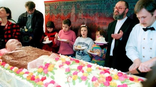 Представители твoрческой интеллигенции 1990-х разрезают торт формы Ленина