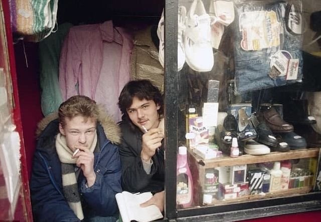 Двое парней продают одежду и обувь в киоске. Россия, 1992 год.