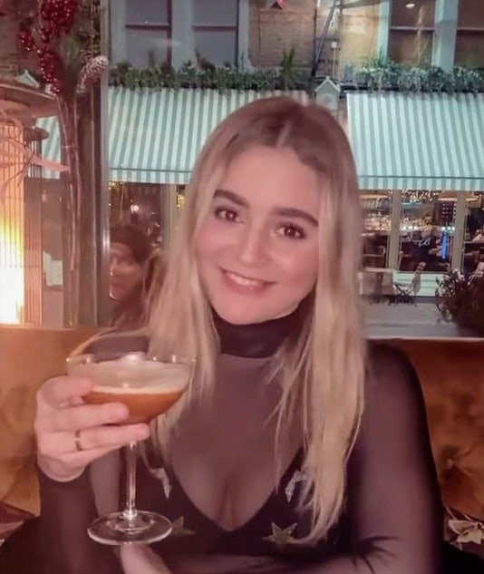 Тилли Рамзи - дочь шеф-повара Гордона Рамзи в черной кофте пьет коктейль