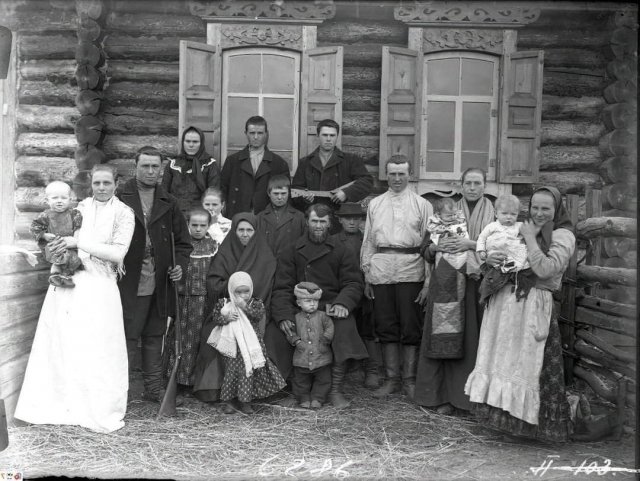 Групповое фото житeлей одного из сёл Енисейской губернии. Кто-то пришёл фотографироваться с ружьём, кто-то с балалайкой. Российская империя. 1910 год