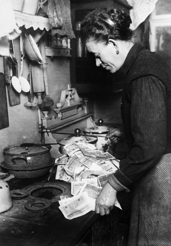 Женщина использует банкноты, чтобы разжечь свою плиту, 1923 год