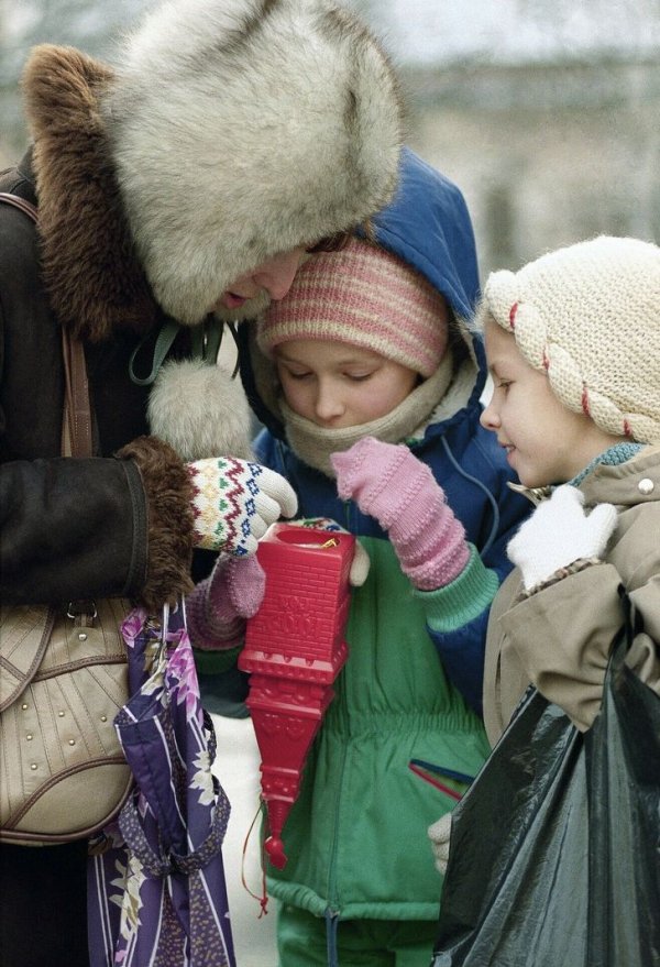 Мать с детьми изучают содержимое пластиковой копии Спасской башни Кремля