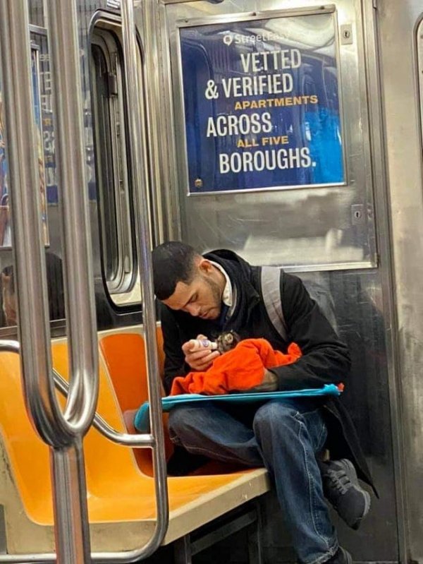 Парень кормит котёнка в метро