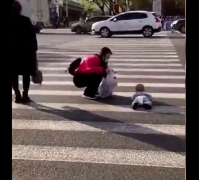 &quot;Яжемать&quot; фотографирует ребенка, ползающего по пешеходному переходу, посреди оживленной трассы