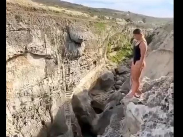 Смелая девушка прыгает в воду с огромной высоты