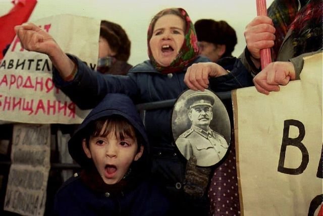 Женщина держит фотографию Иосифа Сталина