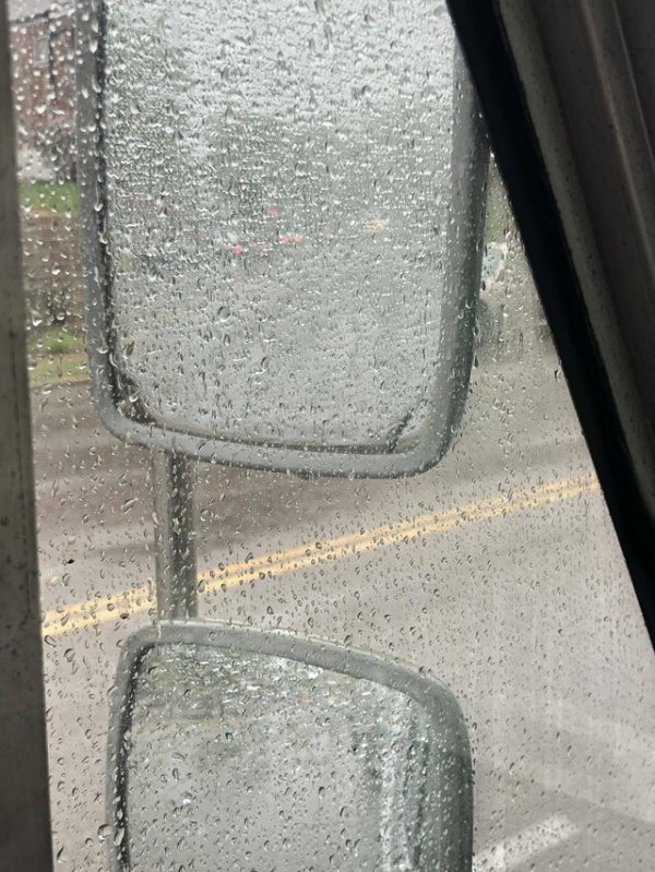 Вид в зеркала заднего вида грузовика, когда идёт сильный дождь
