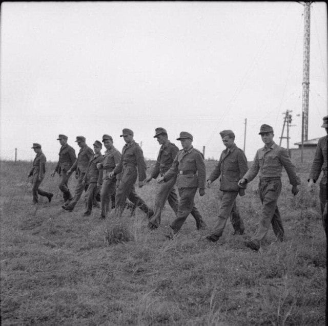 Германские военнопленные после разминирования поля проходят по нему, гарантируя результат. Дания, 1945 г.
