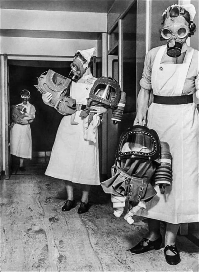 Медсестры несут младенцев в противогазах в лондонской больнице, 1940 год.