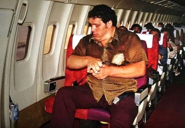 Рестлер и актер Андре Гигант пытается пристегнуться в самолете, 1980-е.