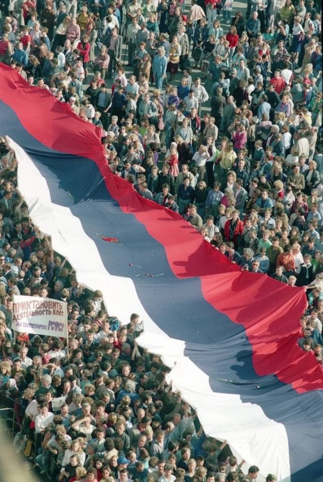 Тысячи москвичей триумфально шествуют в сторону Красной площади с российским триколором, празднуя победу над путчем, 22 августа 1991 года.