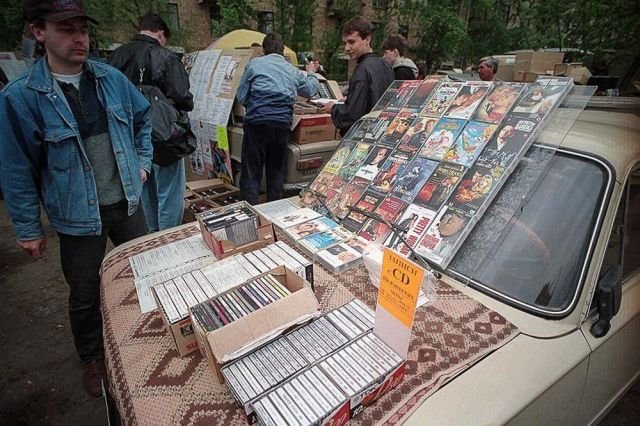 Продажа CD-дисков и кассет на капоте автомобиля, особое внимание привлекает подборка кассет с записями переписанными с CD, 90-е годы.