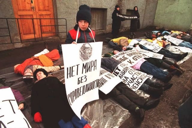 Демонстранты лежат на земле перед Министерством обороны в Москве. 23 февраля 1995 года.