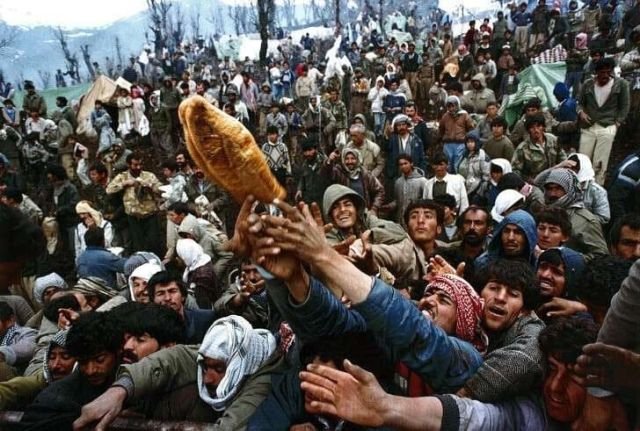 Курдские беженцы борются за хлеб во время раздачи гуманитарной помощи на иракско-турецкой границе, 1992 год.