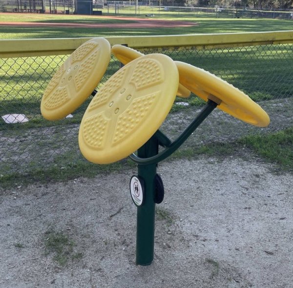 Загадочные желтые пластиковые диски, установленные на металлической подставке возле бейсбольного поля