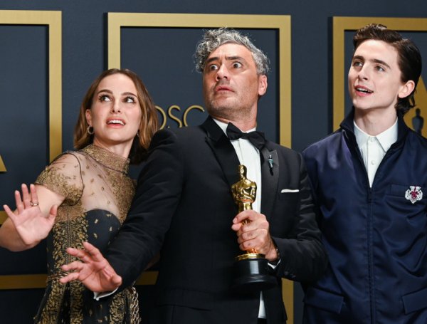 Тайка Вайтити, получивший свой первый «Оскар» за лучший адаптированный сценарий, позирует фотографам вместе с Натали Портман и Тимоти Шаламе