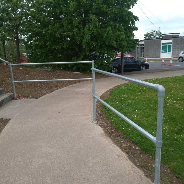 Забор, который преграждает пешеходам путь на тротуаре