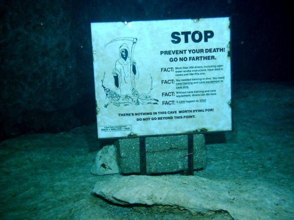 Табличка с предупреждениями, которая стоит у подводной пещеры в Мексике
