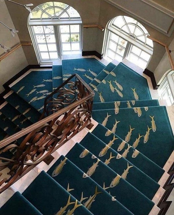 Спиральная лестница с синим ковром, по которому плывут рыбки