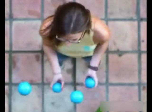 Очень способная девушка показывает, как жонглировать четырьмя шариками