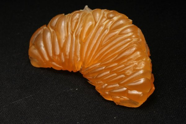 Очищенный ломтик мандарина, который похож на какой-то драгоценный камень