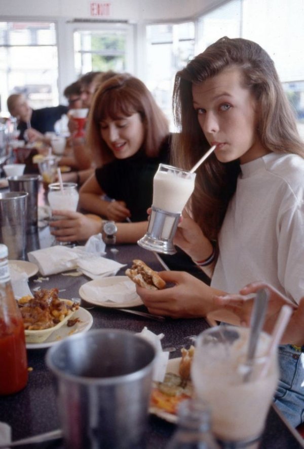 Мила Йовович ест гамбургер с молочным коктейлем в Johnny Rockets на Мелроуз в Голливуде,1987