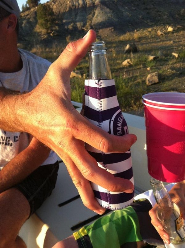 Мужчина может держать бутылку обычного размера между большим и безымянным пальцами