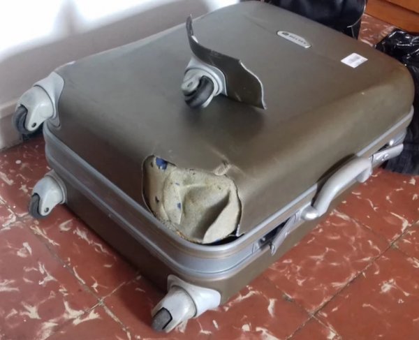 Кто-то из грузчиков швырял чемодан так, что у него отломился кусок пластикового корпуса и колесо